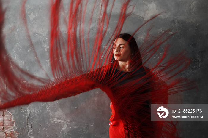 Young adult spanish woman dancing flamenco on gray vintage studio background