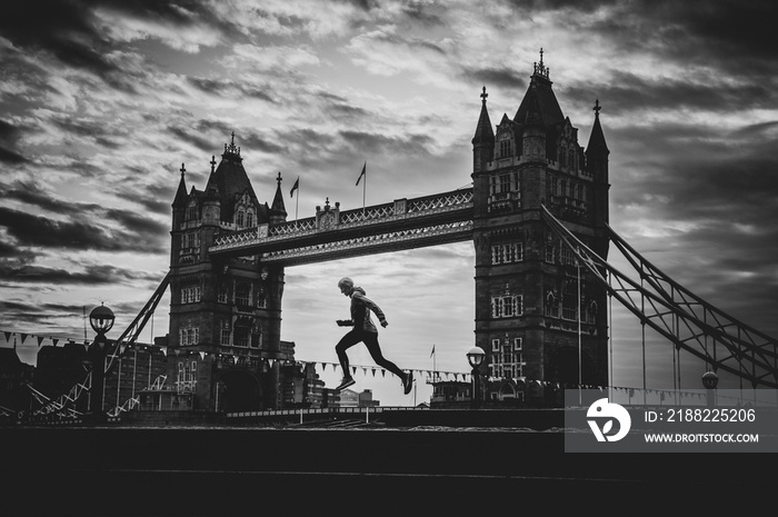 Alone runner in empty streets of london in Coronavirus, Covid-19 quarantine time. Tower Bridge in background