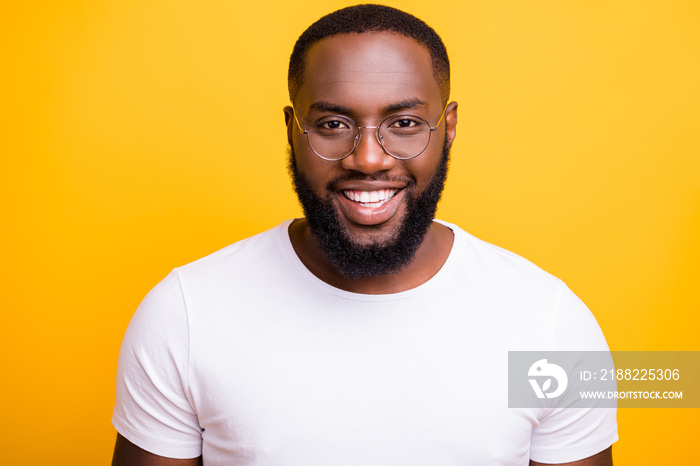 Close up photo of afro american man staring at camera while isolated with bright yellow background