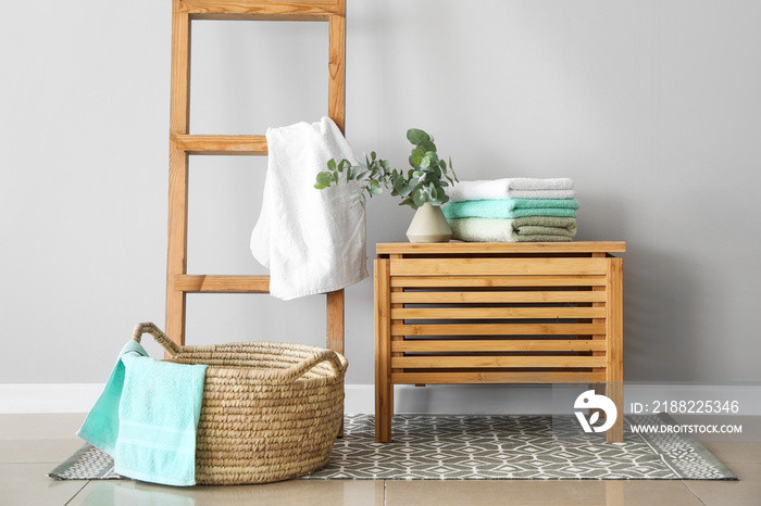 Basket and wooden box with soft towels in room