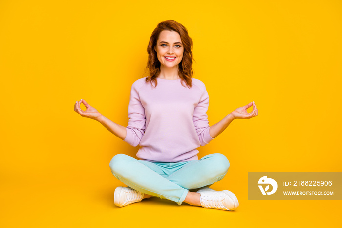 Full body photo of positive cheerful girl sit floor legs crossed meditate yoga show om sign wear pink turquoise outfit white gumshoes isolated over bright color background