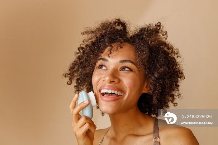 Multiethnic woman toothy smiling on beige background of studio