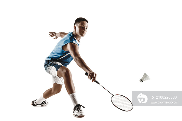 Little boy playing badminton isolated on white studio background. Young male model in sportwear and sneakers with the racket in action, motion in game. Concept of sport, movement, healthy lifestyle.