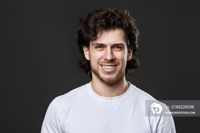 portrait of young smiling man on gray background