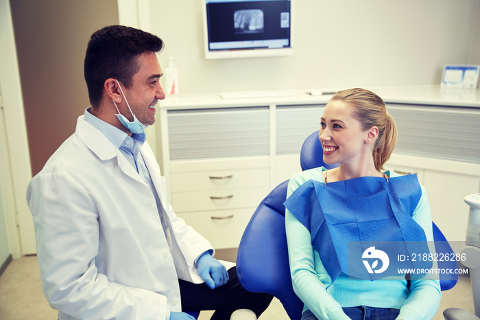 happy male dentist with woman patient at clinic