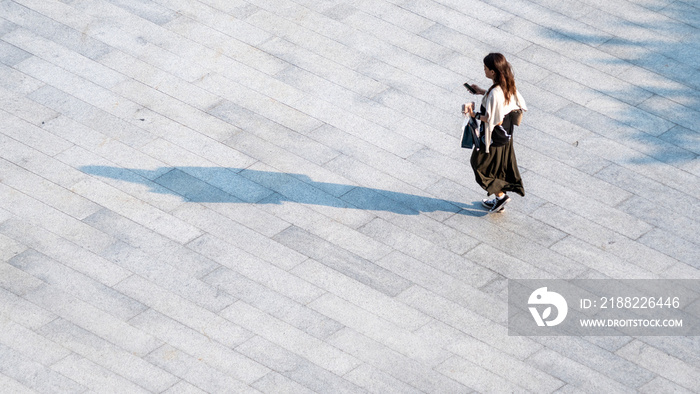 top aerial view people walk on across pedestrian concrete with black silhouette shadow on ground, concept of social still life.