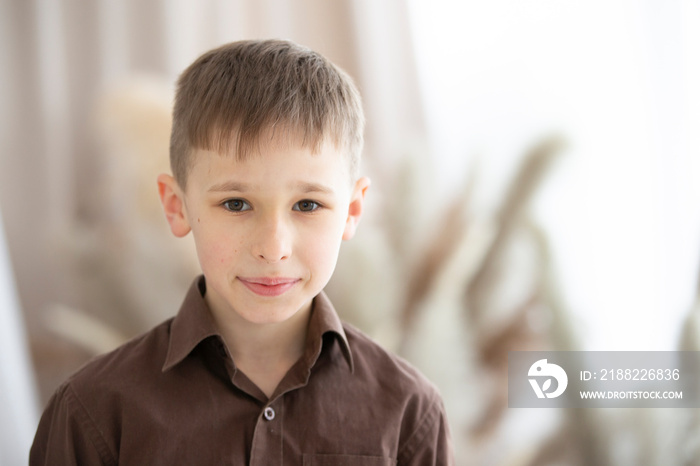 A boy of nine or ten years of European appearance is looking at the camera.