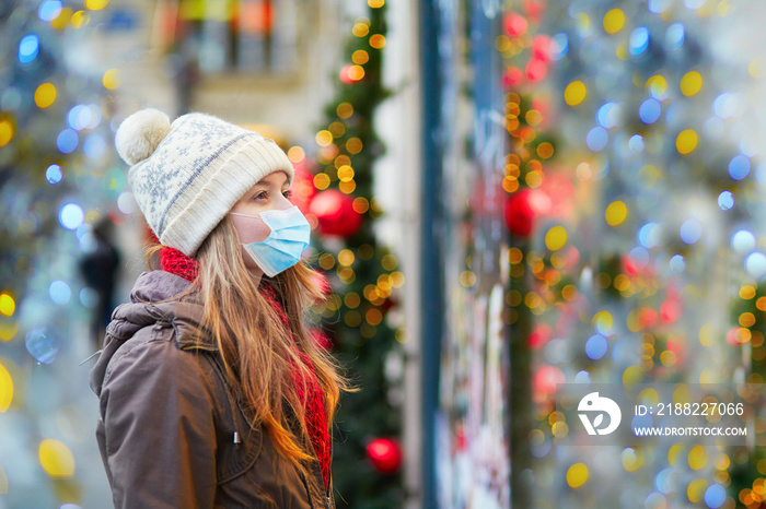 Girl wearing face mask on a Parisian street or at Christmas market