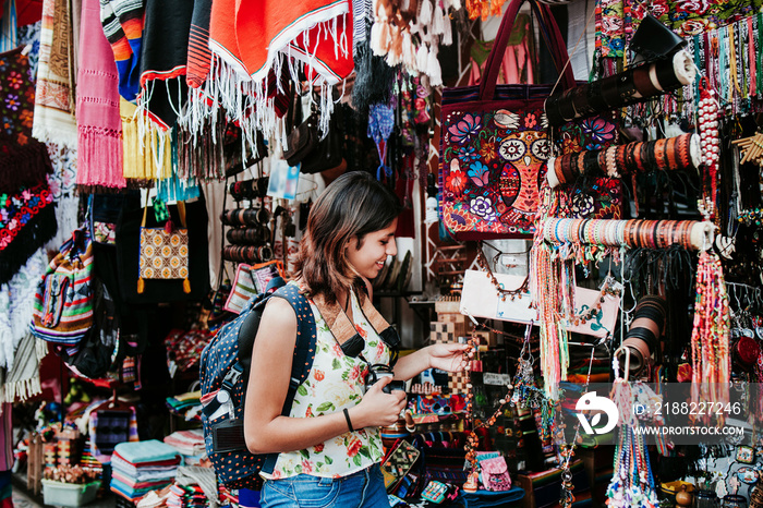 hispanic woman backpacker buying souvenirs  in a traditional mexican Market in Mexico, Vacations