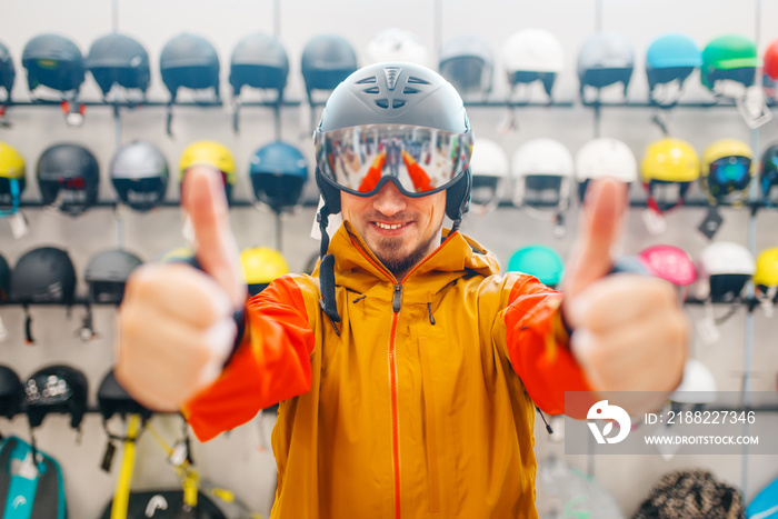 Man in helmet for snowboarding shows thumbs up