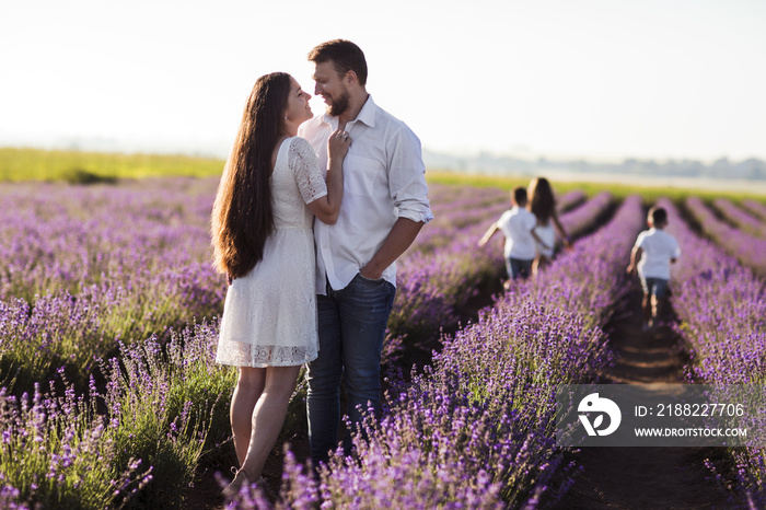 Beautiful young family on purple flower lavender field. Family vacation. Cheery young couple having fun at the lavender field together. lavender field.