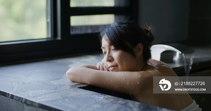 Woman enjoying hot spring and look outside the view