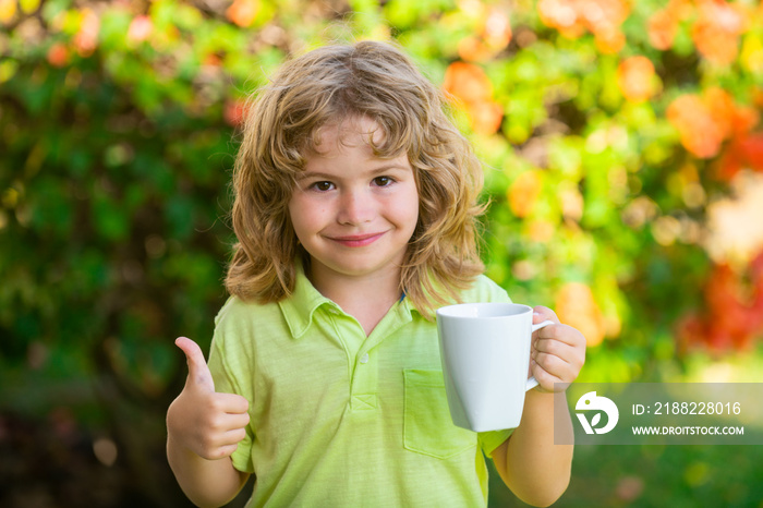 Child drinking tea or water in backyard garden. Healing kids and protect immunity from seasonal virus, health kids concept.