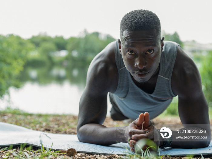 Man exercising doing plank in park