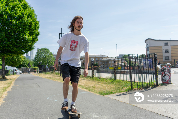 Young man skateboarding on footpath