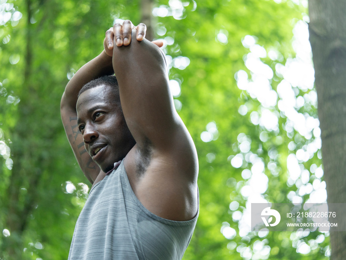 Man stretching after workout in forest