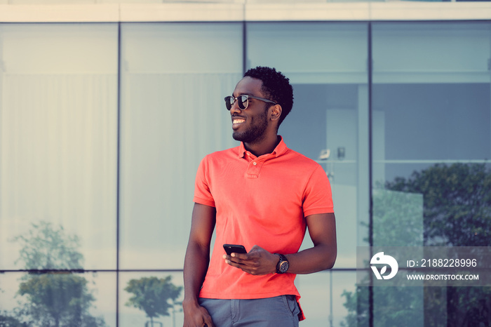 Afro american male in red t shirt texting sms on smartphone.