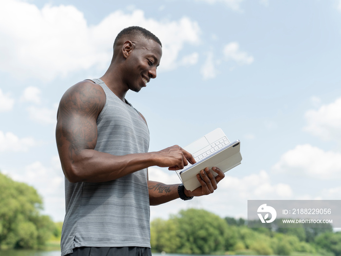 Smiling man using digital tablet outdoors