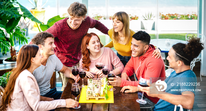 Young friends having fun together tasting wine at rooftop by private house lounge - Happy people eating finger food at restaurant - Dinning life style concept on vivid filter - Focus on central girl