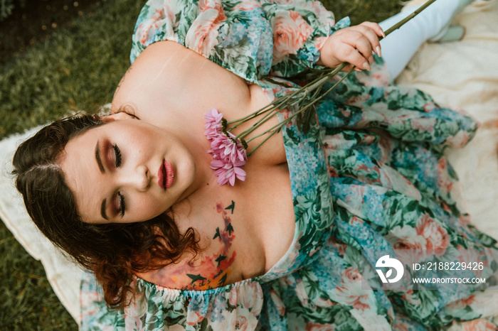 portrait of a plus size woman holding flowers to chest