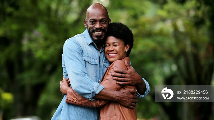 African couple posing outside smiling