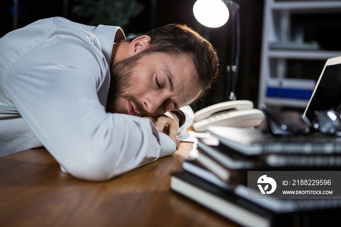 Tired businessman sleeping on the desk