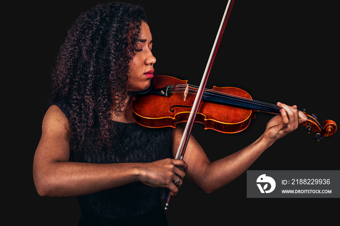 Beautiful young woman playing violin over black