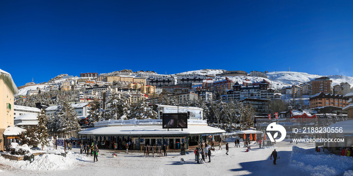 Panoramic view of the main square of Pradollano in Sierra Nevada, Granada. A sunny day after a heavy snowfall in winter.