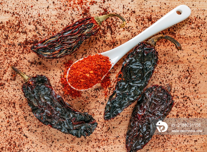 Top view of dried chipotle chili. Chili flakes milled on wooden background