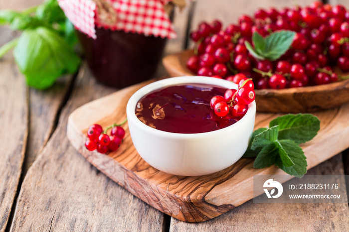 Rustic jar with currant  jam and fresh red currants, homemade preserves marmalade on wood