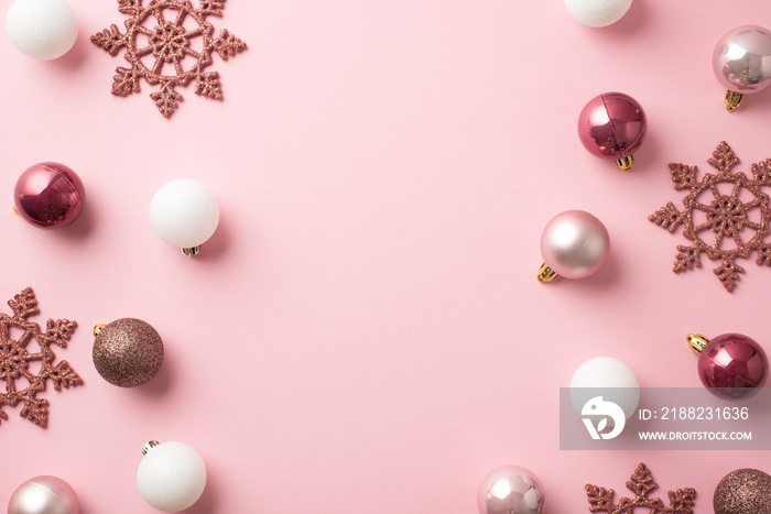 Top view photo of pink and white christmas tree balls and pink snowflakes on isolated pastel pink background with copyspace