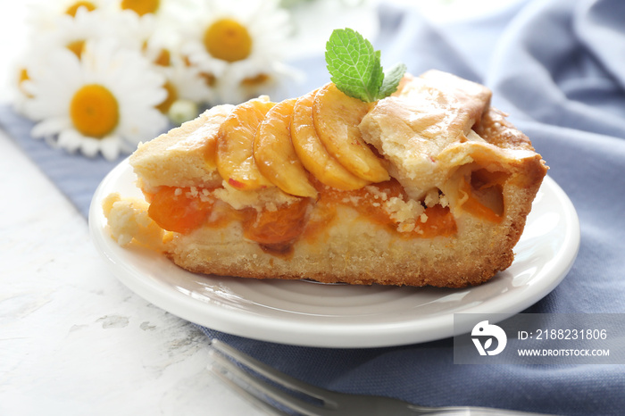 Plate with piece of tasty peach pie on table