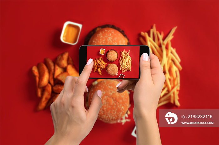 A young woman taking photo of food on smartphone, photographing meal with mobile camera