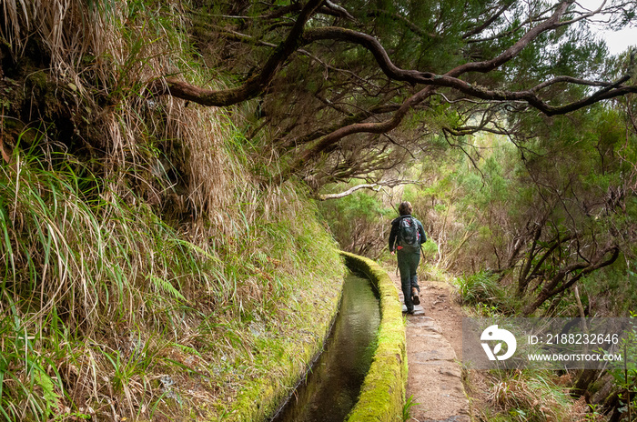 A hiker follows the path along a levada on the island of Madeira