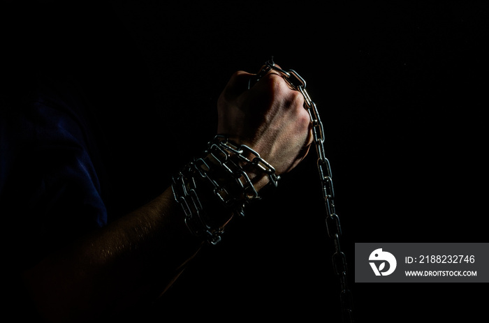 Hands are chained in chains isolated on black background