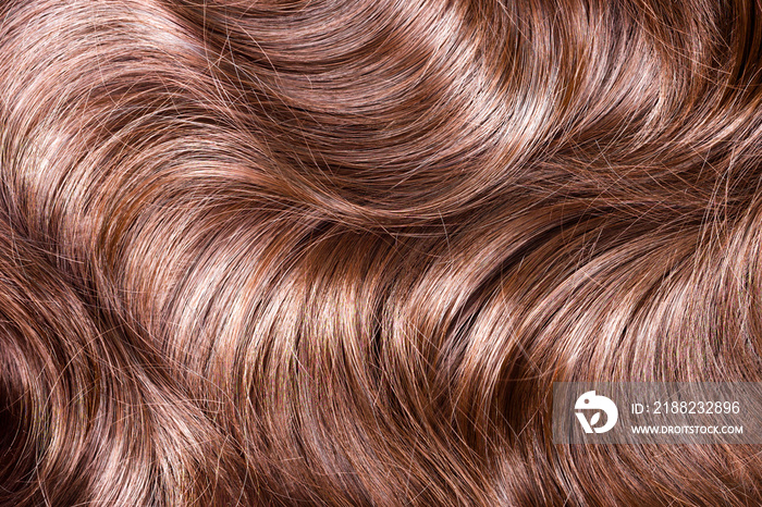 Brown hair texture. Wavy long curly light brown hair close up as background. Hair extensions, materials and cosmetics, hair care. Hairstyle, haircut or dying in salon.