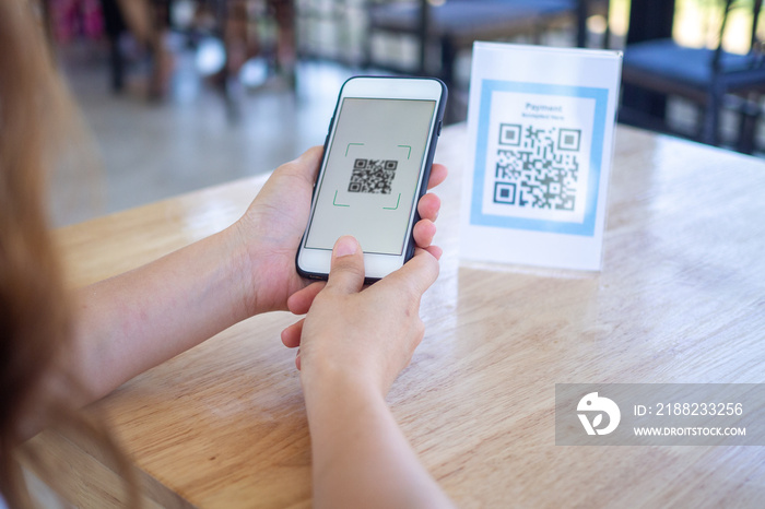 Use a mobile phone to scan the coach’s bar, pay for food. Qr code payment, cashless technology concept illustration. Woman scanning tag in  shop accepted generate digital pay without money.