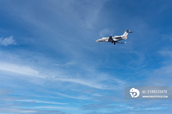 private jet while landing on a blue sky