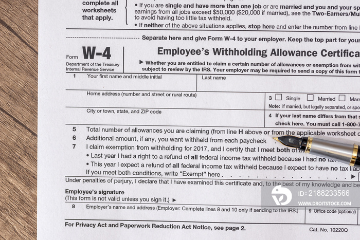 w 4 tax form with pen on desk.