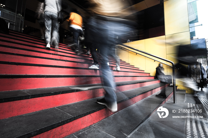 Blurred motion of people walking up the stairs into a building in melbourne, Australia