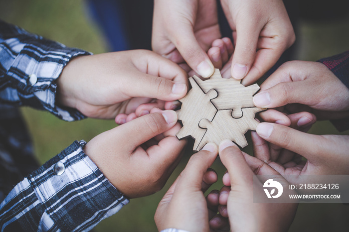 Hands of diverse people assembling jigsaw puzzle, Youth team put pieces together searching for right match, help support in teamwork to find common solution concept, top close up view