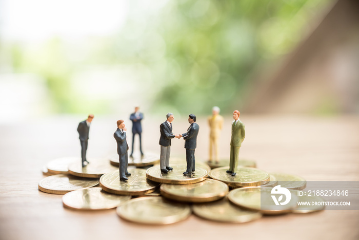 Miniature people standing on coin,Business concept