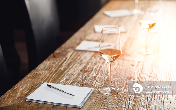 Concept sommelier tasting white wine, row glasses with alcohol and notepad on table, top view