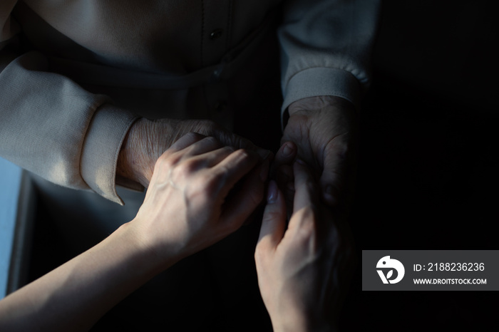 very elderly great-grandmother and granddaughter hold hands