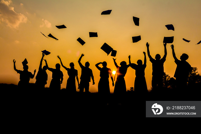 Silhouette group friends graduation holding papers playing throwing at sunset time.