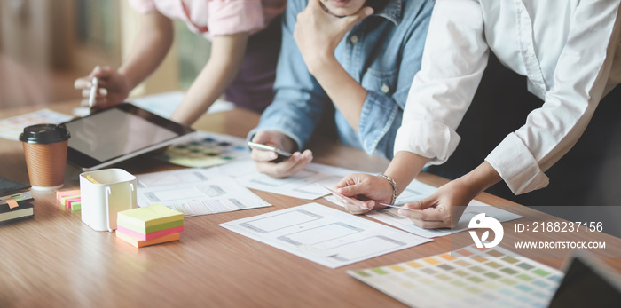 Group of young professional UI graphic designer discussing on their smartphones templates