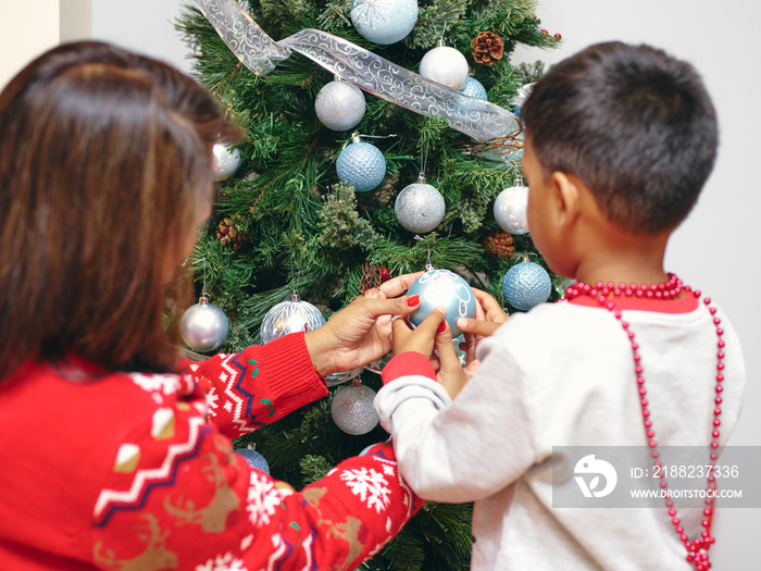 Mother and son decorating Christmas tree