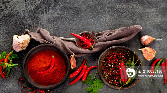 Red chili or chilli cayenne pepper and peppercorns on dark background.