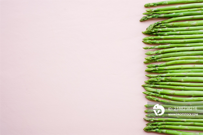 Fresh asparagus on delicate pink background