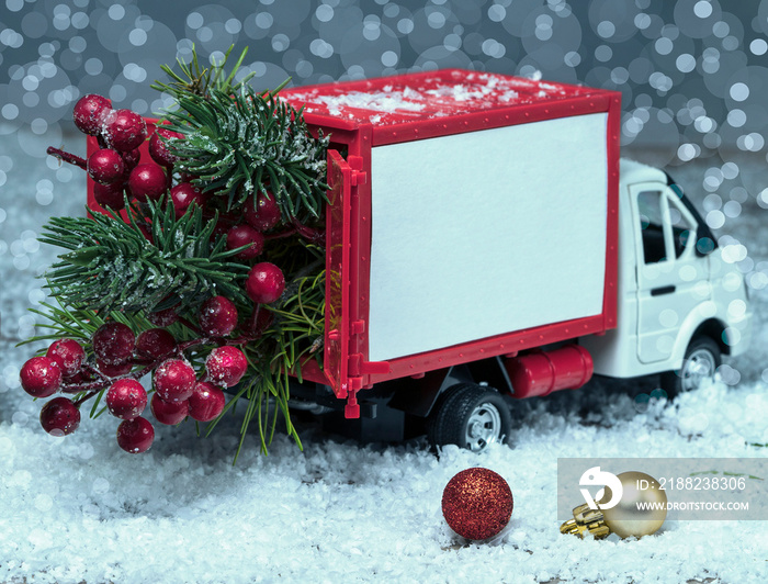 Christmas van on the snow, background with bokeh. The truck is carrying the tree. Delivery